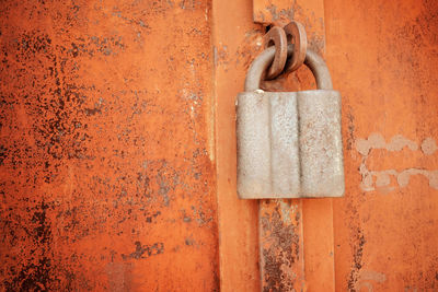 Padlock on a rusty brown metal door. processed for vintage tone effect. rusted iron orange plate