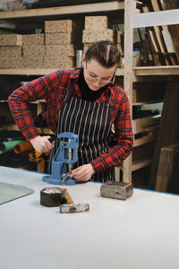 Sewing process. tailor sewing bag at workshop. woman creating accessories on workplace. tailoring