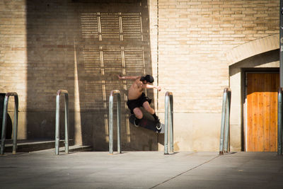 Full length of a young man sitting at entrance of building
