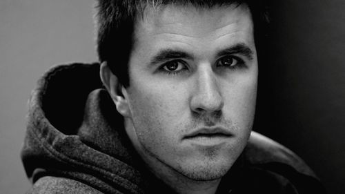 Close-up portrait of young man against gray background