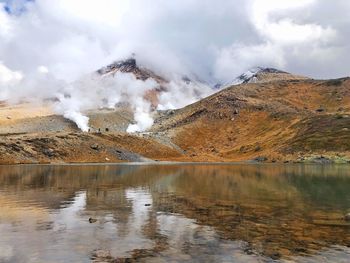 Scenic view of lake by mountain against sky