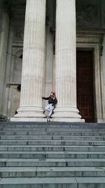 Low angle view of woman leaning on columns of historic church