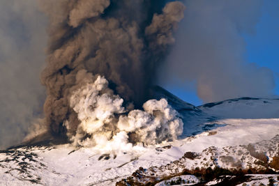 Snow on volcanic mountain against sky