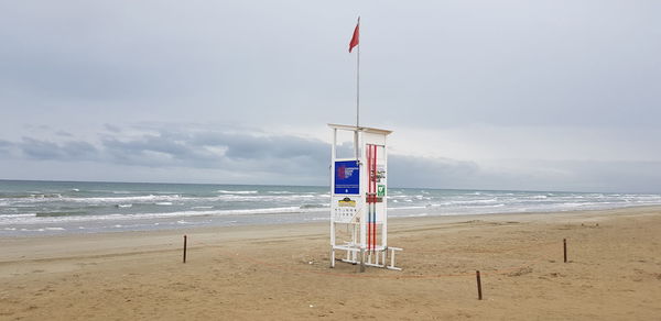 Lifeguard hut on beach against sky