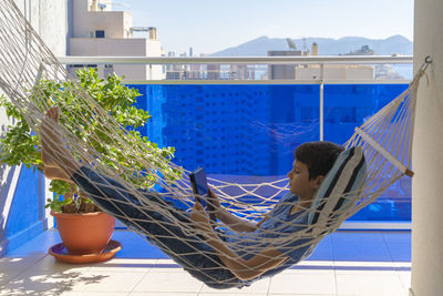 Rear view of girl sitting on potted plant