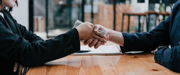 Midsection of business colleagues shaking hands
