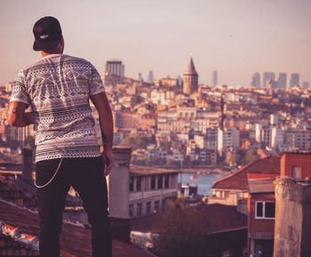 Rear view of man standing against cityscape