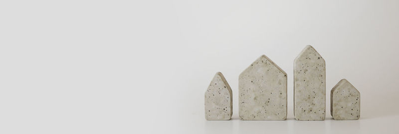 Mini concrete houses on the white background. buy a house. concept for property ladder. free space