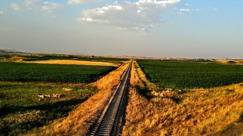 View of railroad track on field against sky