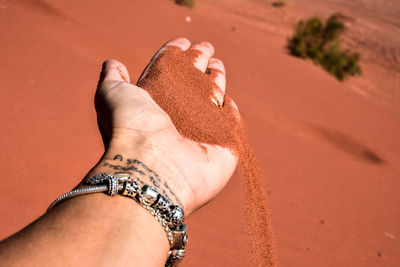 Midsection of woman hand on sand