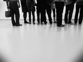 Low section of people standing on tiled floor