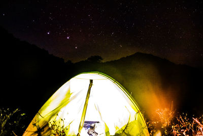 Low angle view of illuminated tent against sky at night