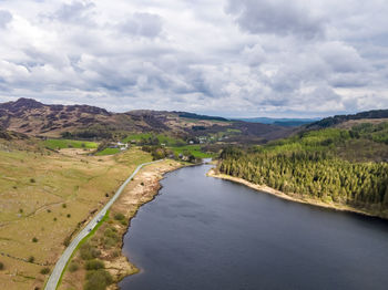 Scenic view of river amidst mountains against sky