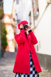 Rear view of man photographing with backpack standing outdoors