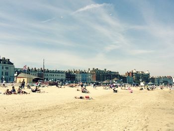 People on beach with city in background