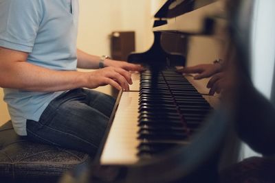 Midsection of man playing piano