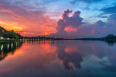 Scenic view of lake against dramatic sky during sunset