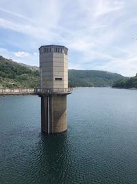 Built structure by lake against sky