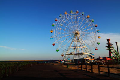 Ferris wheel against blue sky during sunset