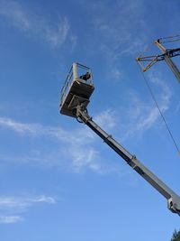 Low angle view of crane against blue sky