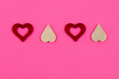 Directly above shot of heart shapes on pink background