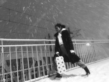 Rear view of woman walking on snow