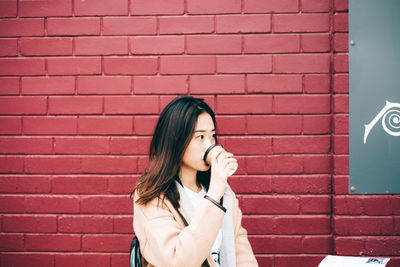 Woman standing against brick wall