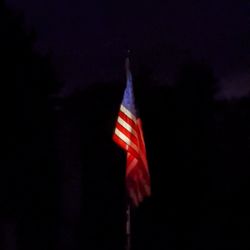 Low angle view of flag against sky at night