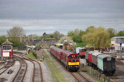 Train on railroad tracks in city against sky