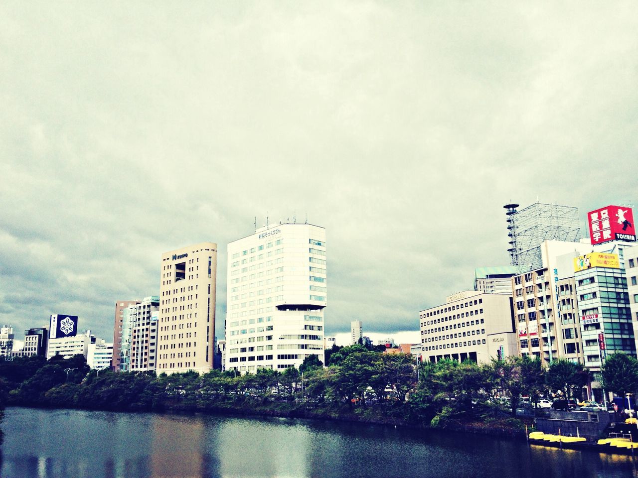 building exterior, architecture, built structure, sky, city, water, waterfront, building, cloud - sky, cloudy, text, day, residential building, reflection, modern, tower, tall - high, cloud, outdoors, skyscraper