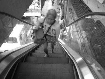 Rear view of people on escalator at railroad station