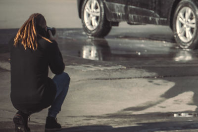 Rear view low section of woman walking on road