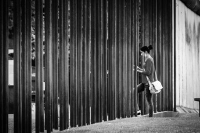 Side view of woman walking through fence