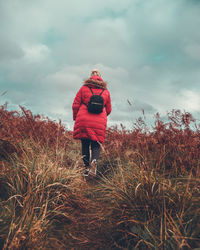 Rear view of woman on field against sky