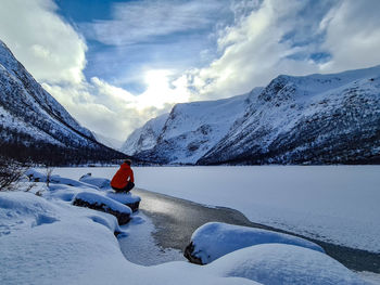  hiker and frozen lake against snow covered mountains 