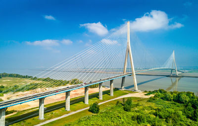 View of suspension bridge against cloudy sky