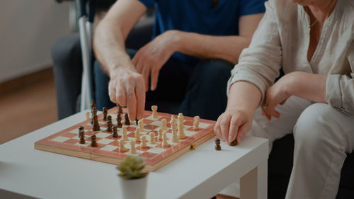 Midsection of man and woman playing chess