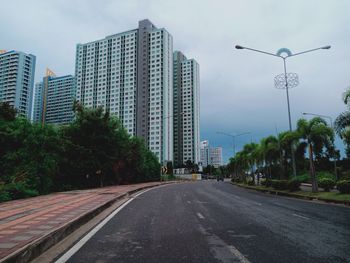 Street amidst buildings against sky in city