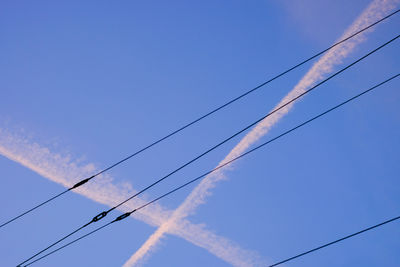 Low angle view of vapor trail against blue sky