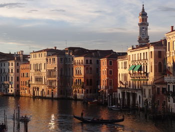 Canal in city against sky