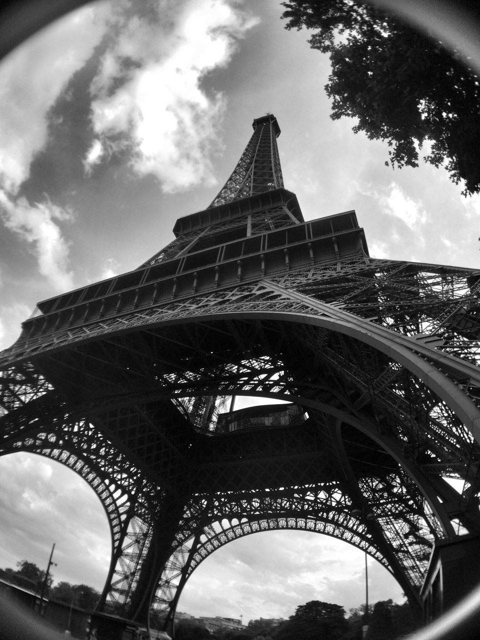 tourism, architecture, international landmark, travel destinations, low angle view, famous place, built structure, eiffel tower, capital cities, sky, culture, tower, travel, tall - high, arch, city, building exterior, tall, architectural feature, cloud - sky, history, iron - metal, outdoors, day, spire, vacations, 19th century style, majestic, city life, monument, cloudy