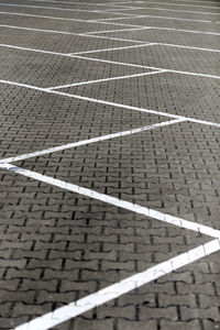 Parking road marking on brick pavement without cars. white road surface marking lines in car parking