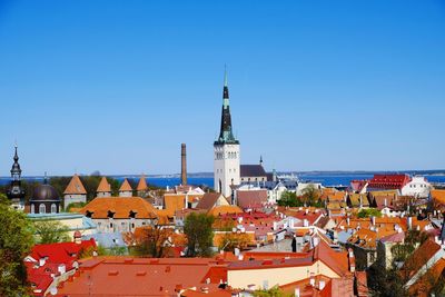 Buildings in city against clear blue sky