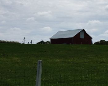 Scenic view of grassy field against cloudy sky