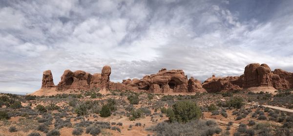 Rock formations on landscape against cloudy sky