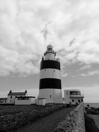Low angle view of lighthouse amidst buildings against sky
