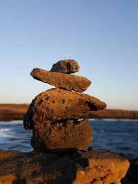 Close-up of rocks in sea against clear sky