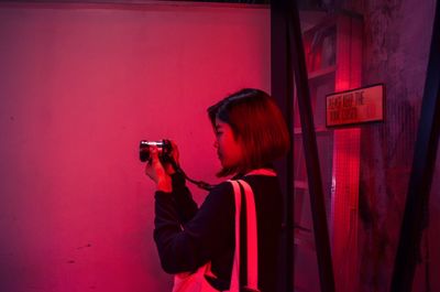 Woman photographing with red umbrella