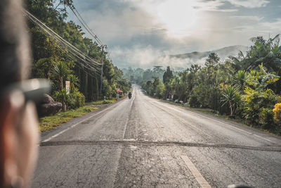 Road with trees against sky