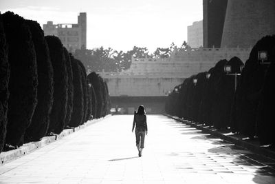 Rear view of man walking on road
